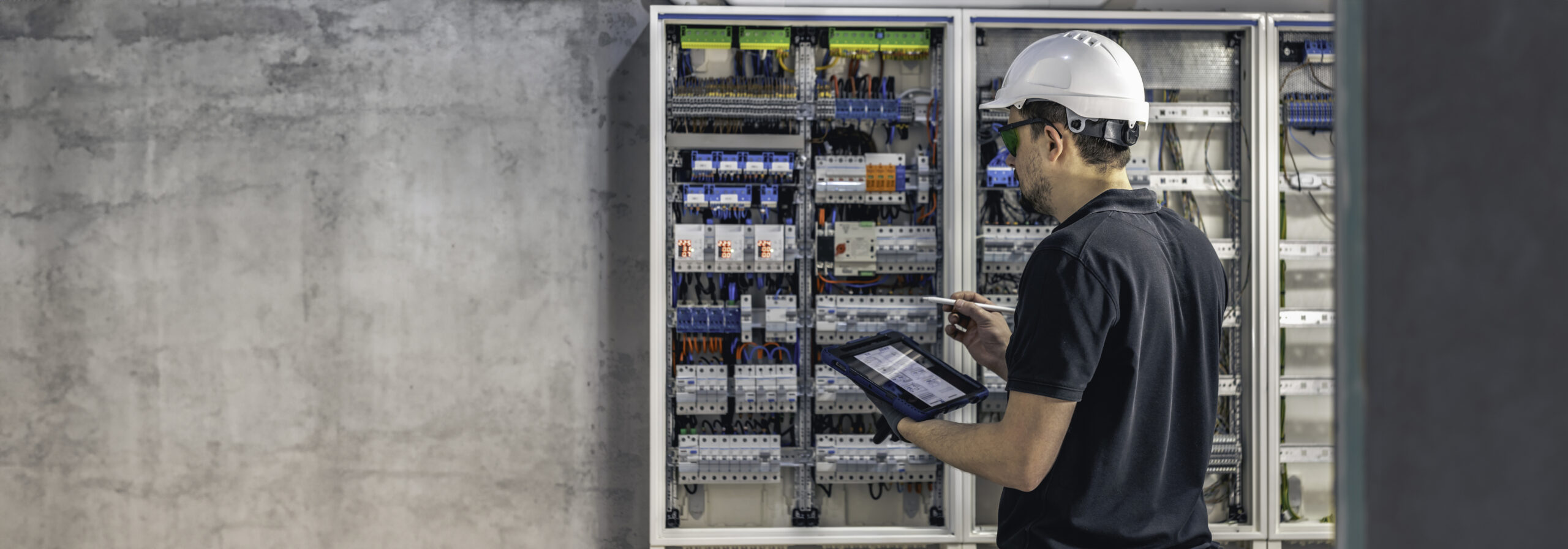 Man, an electrical technician working in a switchboard with fuses.